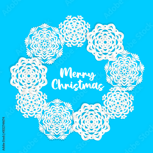 Beautiful circle frame from white Christmas applique snowflakes of different shapes and sizes on blue background