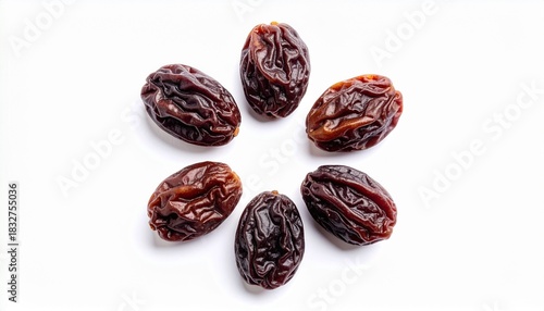 Five dried raisins with wrinkled texture on white background