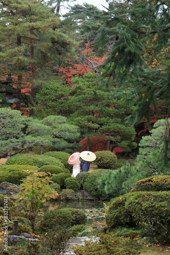 Couple Holding Umbrellas in a Japanese Garden