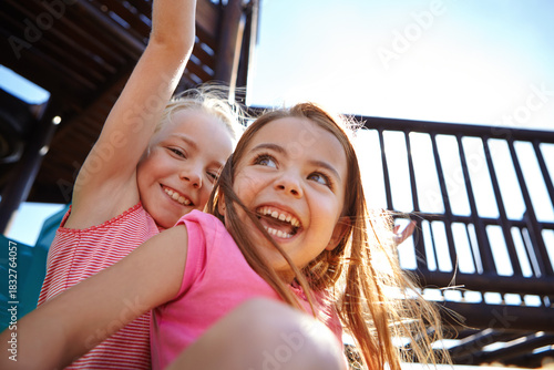 Fotografie Playground, fun and children on slide, laugh and friends on summer holiday, play and happy together
