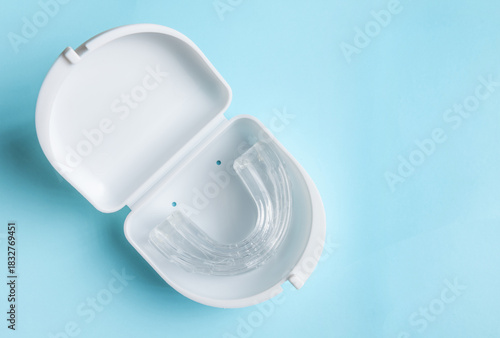 Anti snoring mouth guard made of reusable silicone shown on a white table or blue backdrop. The device is displayed from a side view or top view, clean and minimal, medical product style.