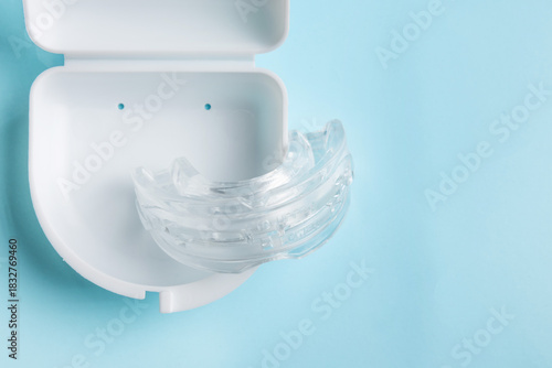 Anti snoring mouth guard made of reusable silicone shown on a white table or blue backdrop. The device is displayed from a side view or top view, clean and minimal, medical product style.