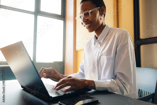 Smiling professional woman working on a laptop indoors
