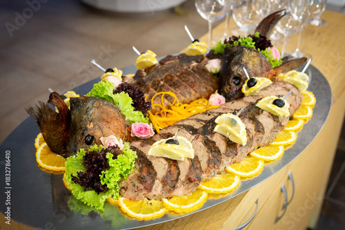 A dish of fish divided into pieces and cooked with lemon and vegetables.