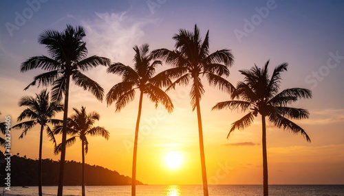 Tropical island sunset with silhouette of palm trees, hot summer day vacation background, golden sky with sun setting over horizon
