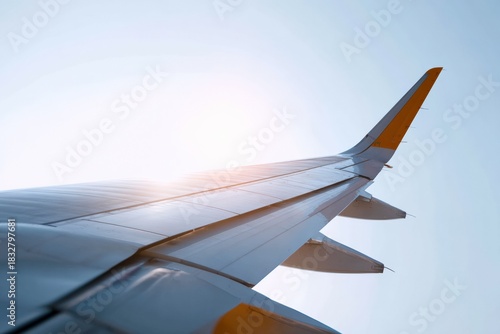 Sunlit airplane wing in blue sky with bright horizon