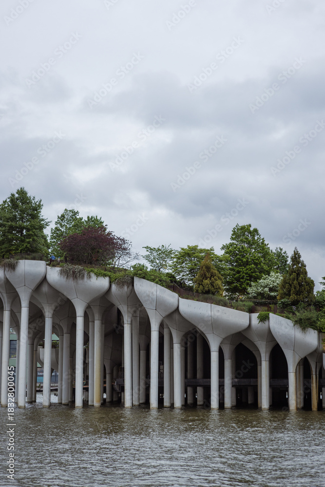 Fototapeta premium Modern Floating Park Over Water. Little Island, NYC. modern architectural pier by the water, a stunning photo capturing a modern architectural pier with unique, sculptural columns