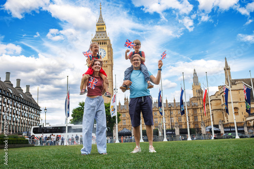 Sticker Smiling family poses with Union Jacks by iconic London landmark