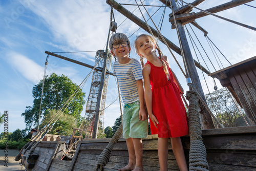 Photography Children explore a wooden ship in bright summer weather at park