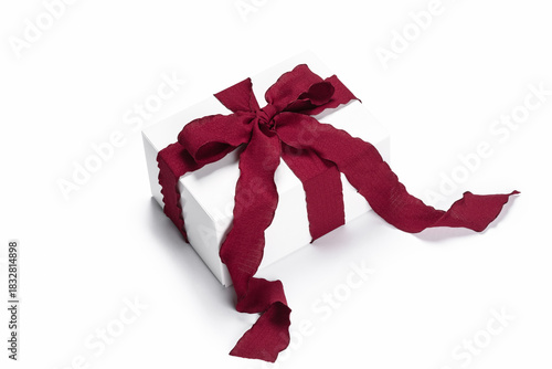 White gift box with burgundy ribbon on white background