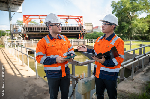 Two Asian engineers are inspecting the wastewater treatment system, wastewater treatment system maintenance engineer