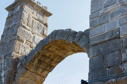 Stone archway and pillars against a clear blue sky