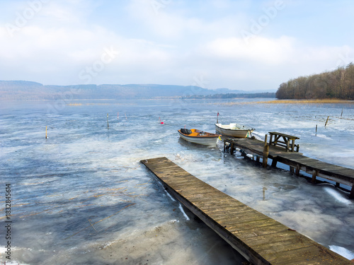 A small boats are trapped in the ice of lake in Sweden during winter.
