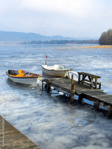 A small boats are trapped in the ice of lake in Sweden during winter.