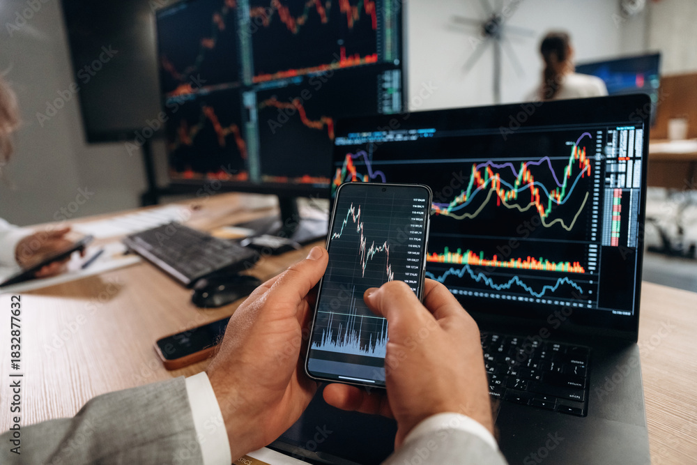 Fototapeta premium Close up view of hands of business men that are working with stock market exchange