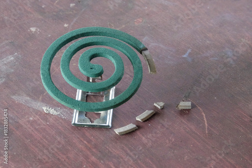 Close up of mosquito coils on a wooden table. Green spiral-shaped mosquito coil. Mosquito repellent. For graphic design, 3D rendering and banners
