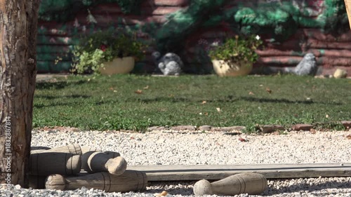 Bowling with wooden skittle ninepins and ball outdoor in the park
