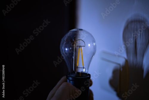 A glowing lamp in a hand. Power outages due to the war in Ukraine.