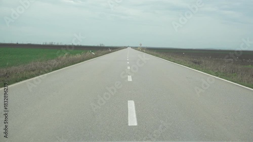 Ahead view low angle car drive on long straight empty road