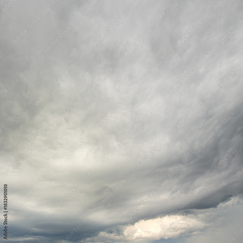 Obraz premium Expansive dramatic overcast sky filled with swirling grey white clouds.