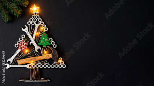 Creative Christmas tree made from mechanic's tools and hardware on black background. Text space