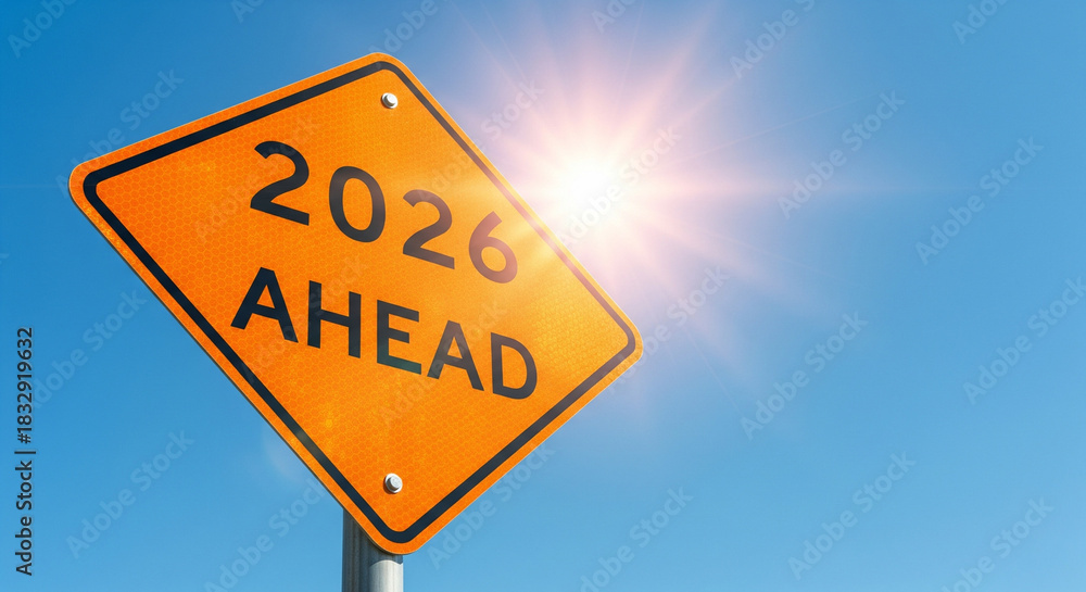 Naklejka premium An orange reflective road sign reading 2026 AHEAD is set against a bright blue sky, symbolizing the future, upcoming challenges, and the new year