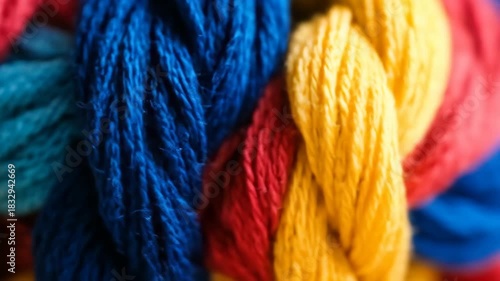 Close-up of vibrantly colored embroidery floss, with threads of blue, red, and yellow intertwined in a twisted pattern, perfect for crafting and textile art projects.