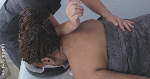 Female chiropractor therapist doing back massage to a senior woman patient inside her studio - Healthcare, wellness and healthy lifestyle concept