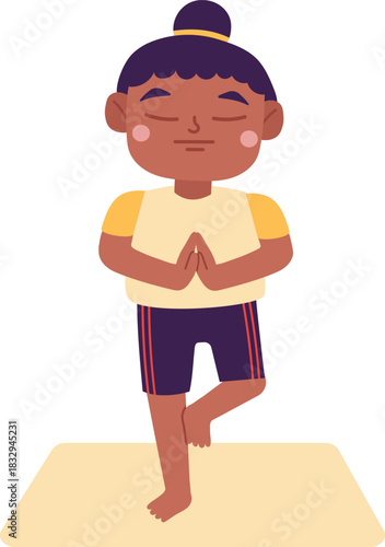 Child balancing in tree pose on yoga mat practicing yoga
