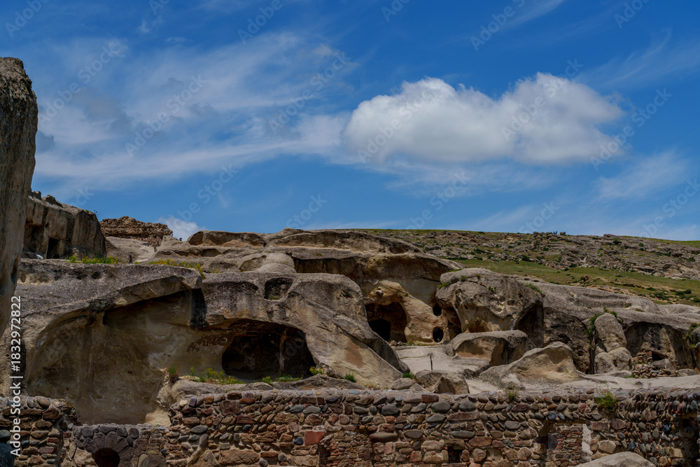 Naklejka premium Rock cut caves and walls in Uplistsikhe under blue sky