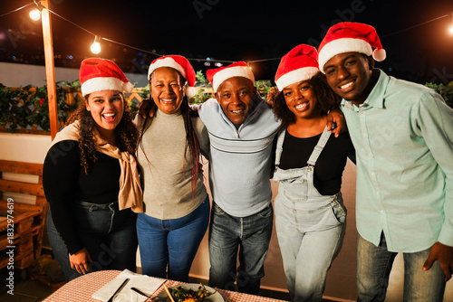 Happy african family having fun hugging each other during Christmas dinner - Holiday concept - Main focus on mother face