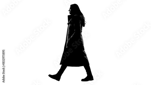 Silhouette of a woman walking confidently in a long coat  