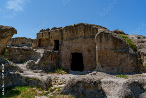 Rock hewn cave dwellings in Uplistsikhe under blue sky