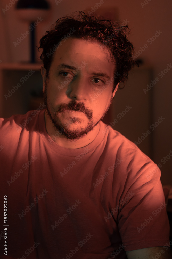 Fototapeta premium Intense Portrait of Man with Beard in Strong Red and Orange Light