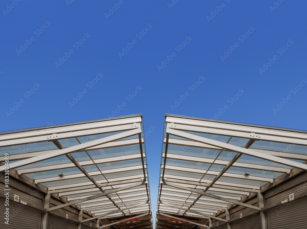 Obraz premium Minimalistic Glass Roof With Metal Support Beams in Modern Architectural Design Under Blue Sky for Construction Engineering Industries, Urban Bazaar Infrastructure, Retail Trade, Dir Designs.