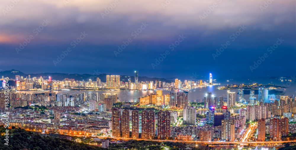 Obraz premium Cityscape at night with illuminated buildings and urban lights