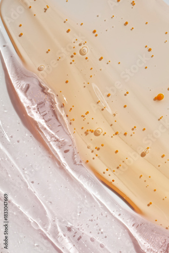 Cosmetic beauty product texture sample swatch. Two products mix. Beige yellow gel serum mask or peeling and pink translucent cream balm.