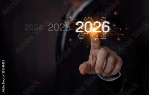 Business professional touching the 2026 icon with AI background, symbolizing future technology.