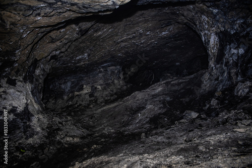 Dark Rock Chamber Interior with Textured Walls and Moody Lighting