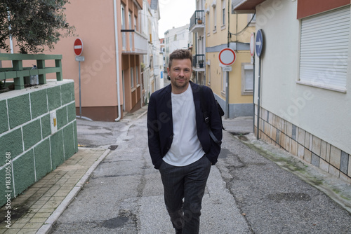 Middle aged man walking through narrow streets of Portugal