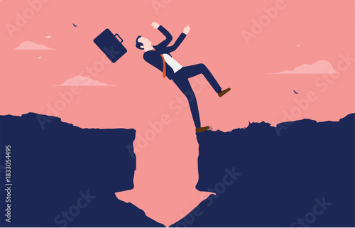 Business crisis - Businessman tripping and falling into gap in the shape of an arrow pointing down. Trouble and misfortune concept