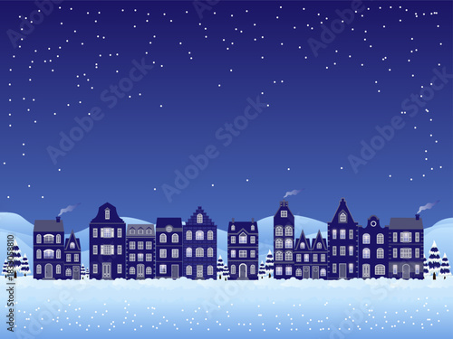 A winter night scene featuring a charming row of old-style houses softly illuminated against a deep blue sky, while delicate snowflakes sparkle in the night air.