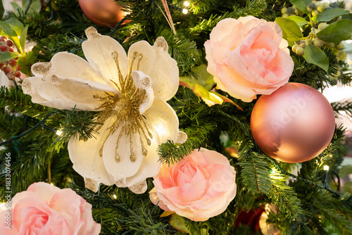 A lush Christmas tree adorned with pink roses, cream flowers, and rose gold ornaments creates a warm, festive vibe. Perfect for holiday, home decor, and romantic seasonal themes.