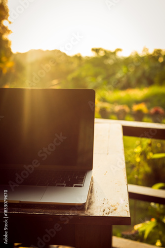 Wallpaper Mural Laptop with backlight on wooden table on terrace in tropical forest at sunset, remote work digital nomad Torontodigital.ca