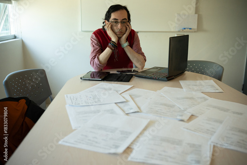 Stressed Male Professor With Head in Hands at Desk, Male Educator Experiencing Burnout and Despair