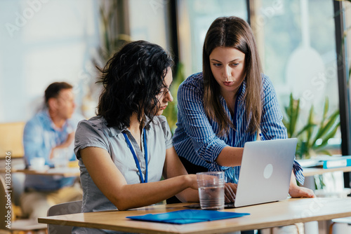 Two Female Startup Team Members Preparing Pitch Presentation Notes at Conference Venue Cafe