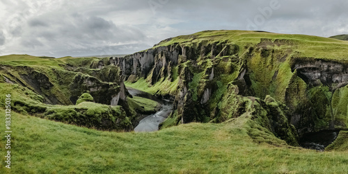 A gorge and a canyon Fjadrargljufur in Iceland. Panoramic photography. The concept of postcards and travels. Green grass and picturesque cliffs.