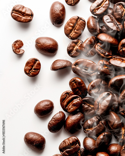 Roasted coffee beans scattered on a white surface with delicate rising steam. Rich aroma and fresh roast concept.