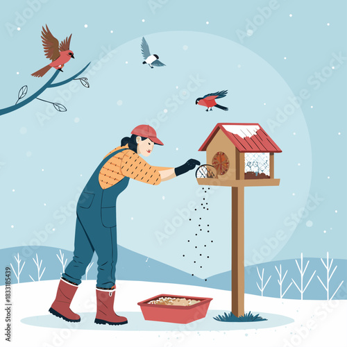 Una mujer alimenta a los pájaros en invierno, vertiendo semillas en una casita de madera rodeada de aves.
