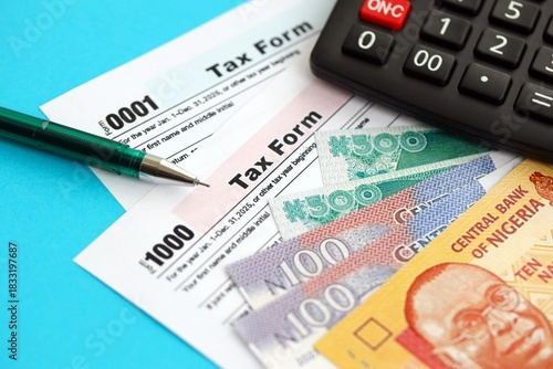 Nigerian naira money bills and calculator with tax form close up. Taxation and accounting concept